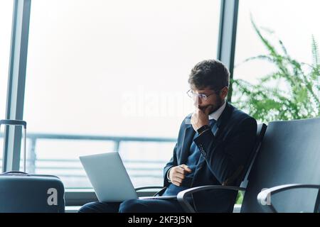 thoughtful business man with a laptop sitting in the airport waiting room. Stock Photo