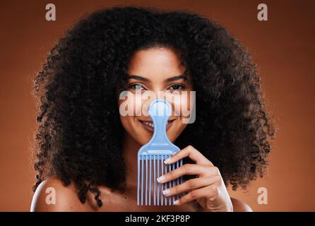 Beauty, hair care and portrait of black woman with comb for afro, natural and curly hair on brown background. Hair salon, cosmetics and girl with hair Stock Photo