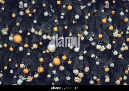 Decorated Christmas tree closeup. golden balls. New Year baubles macro photo with bokeh. Winter holiday light decoration Stock Photo