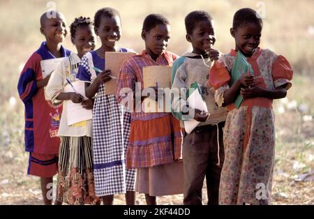Burkina Faso, Fada; Schoolchildren with notebooks standing in line outside. Stock Photo