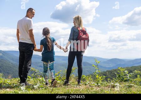 Family stay on the top of mountain, looking on the beautiful view. Stock Photo
