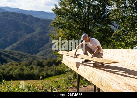 Young manual worker standing at stack with thin wooden boards during his work at furniture factory Stock Photo