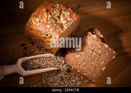 Ein frisches Brot mit Kürbiskernen zur gesunden Ernährung. Backwaren, Schwarzbrot, Getreide auf einer Schaufel, Stock Photo