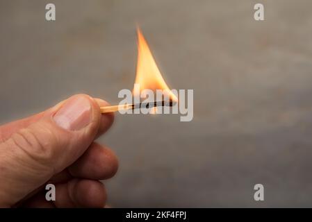 Male hand holding burning match stick Stock Photo