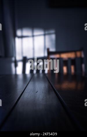 Low sunlight with shadows cast on a wall with table and chair Stock Photo