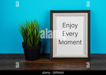 Picture frame with inspirational text Enjoy every moment Stock Photo