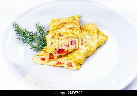 Omelette with tomatoes, spinach and green onion on white plate. Frittata - italian omelet. Stock Photo