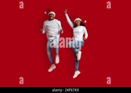 Happy african american xmas lovers having fun on red Stock Photo