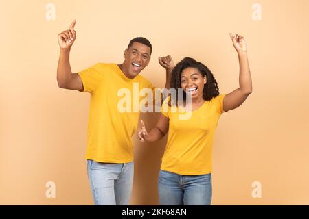 Excited young black couple dancing and enjoying favourite music, fooling around and having fun together Stock Photo