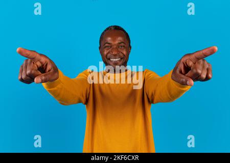 Charismatic handsome black man pointing fingers at camera and smiling Stock Photo