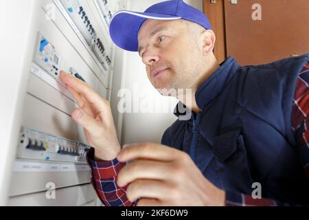 electrician installing energy saving meter Stock Photo