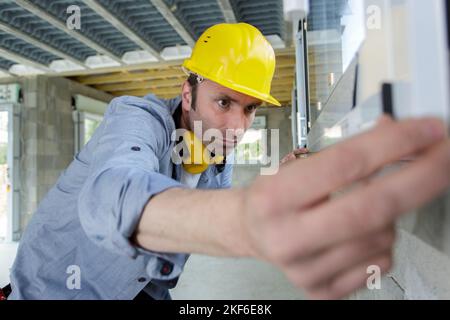portrait of skilled professional bricklayer using special equipment and tools Stock Photo