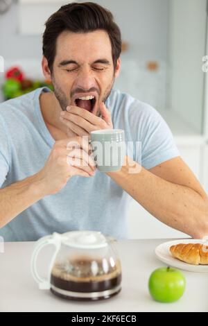 man falling asleep during his breakfast Stock Photo