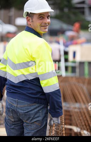 cheerful construction worker pushing a wheelbarrow Stock Photo