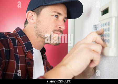contractor entering code on keypad Stock Photo