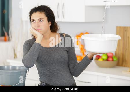 depressed woman catching leaking water from above Stock Photo - Alamy