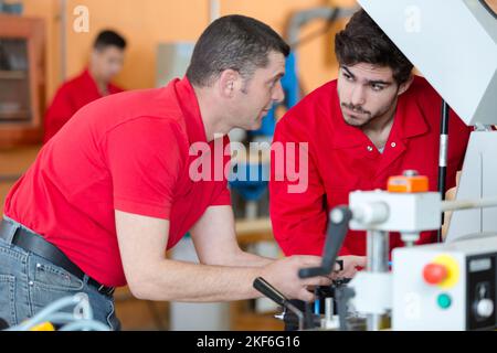 two men operating machines in factory Stock Photo