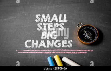 Small steps big changes. Compass on chalkboard background. Stock Photo