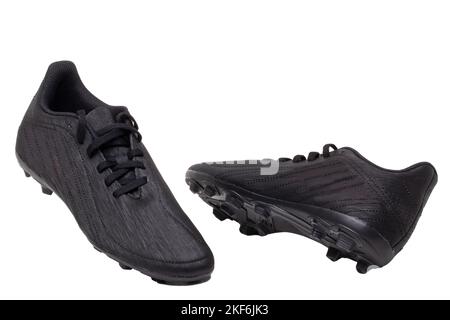 Closeup of a pair of black leather football boots isolated on white background. Professional athletics boys outdoor training shoes. Sports shoes. Stock Photo