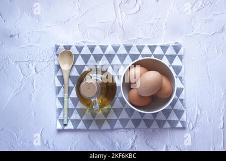 top view of eggs in a bowl and oil on table  Stock Photo