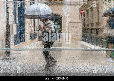 People Walking In The Street During Heavy Rain, Ortigia, Syracuse (Siracusa), Sicily, Italy Stock Photo