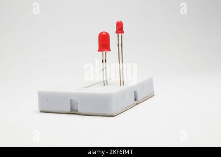 Two LEDs (Light Emitting Diodes) embedded in a small project board side view on a white background. Stock Photo