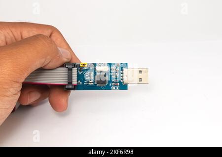 An AVR microcontroller USB downloader held in one hand. Stock Photo