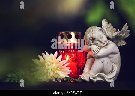 Funeral candle, flower and angel figurine on black background. Sympathy card Stock Photo