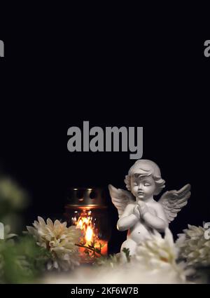 Funeral candle, flower and angel figurine on black background. Sympathy card with copy space Stock Photo