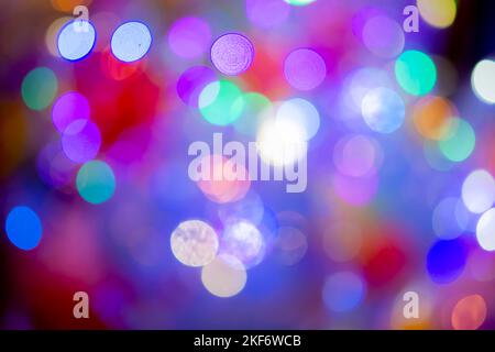 Festive flashing abstract background. Blurred texture background with round bokeh spots. Multicolored blinks background. Celebration New Year Christmas Birthday party holiday Flickering illumination Stock Photo