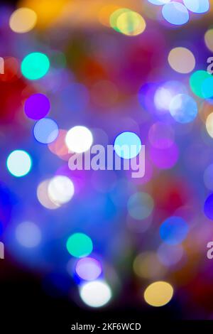 Festive flashing abstract background. Blurred texture background with round bokeh spots. Multicolored blinks background. Celebration New Year Christmas Birthday party holiday Flickering illumination Stock Photo
