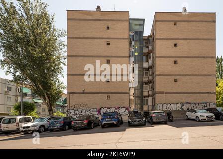 Facades of twin white brick buildings with an external elevator between them Stock Photo