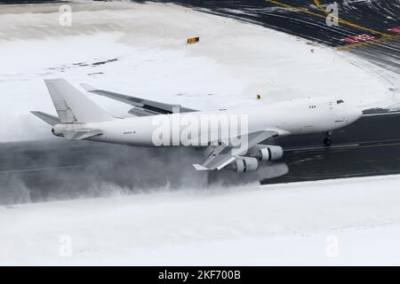 Boeing 747 cargo aircraft landing at Anchorage Airport after a heavy snow fall. Airplane 747-400F of Atlas Air with engines reverse thrust open. Stock Photo