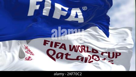 Doha, QA, nov 2022: Flags with FIFA and Qatar 2022 World Cup logo waving in the wind. The event is scheduled in Qatar from 21 November to 18 December Stock Photo