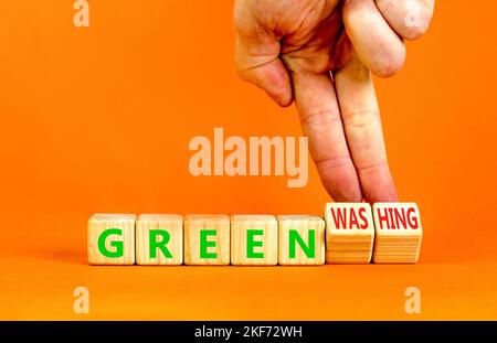 Green or greenwashing symbol. Concept words Green and Greenwashing on wooden cubes. Businessman hand. Beautiful orange table orange background. Busine Stock Photo