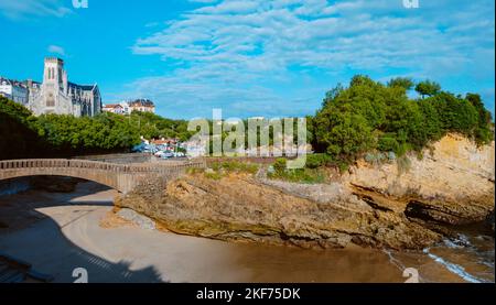 a view of the Rocher du Basta in Biarritz, France, with the Port des Pecheurs, the fishermen port, and the Sainte-Eugenie Church in the background Stock Photo