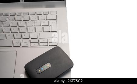 Top view portable pocket internet wifi modem.Close up pocket modem, isolated white background on top of computer.  Copy space. Stock Photo