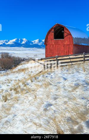 old red barn in the flathead creek valley below the bridger mountains in winter near wilsall, montana Stock Photo