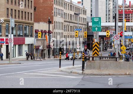 Ottawa, Canada - November 11, 2022: Busy Rideau street in downtown district. Cityscape with intersection, traffic lights, and walking people. Stock Photo