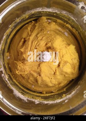 Homemade saffron dough in a food processor for baking buns for December holidays. Stock Photo