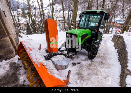 Snow plow truck in winter on path. Green color and modern design. Stock Photo