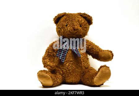 stuffed brown teddy bear with a plaid bow tie Stock Photo