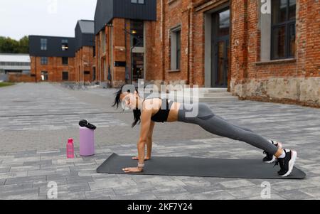 Woman doing push ups outdoor Stock Photo