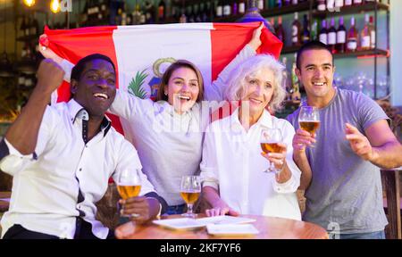 Diverse group celebrating with Peruvian flag Stock Photo