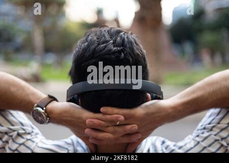 Man on his back resting with his arms on his head Stock Photo