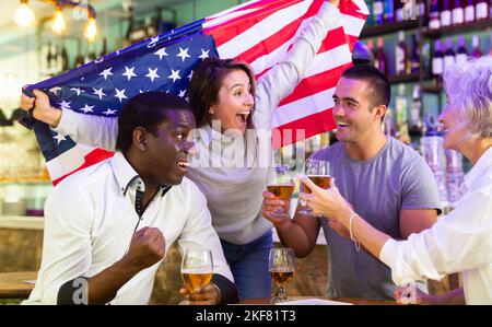 Diverse group celebrating with American flag Stock Photo