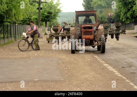 Prahova County, Romania, May 1990, a few months after the fall of communism. Local people with various types of transportation on the main road of the village. Stock Photo