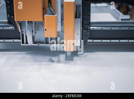 Digital die cut machine cutting plastic sheet. Industrial manufacture. Stock Photo