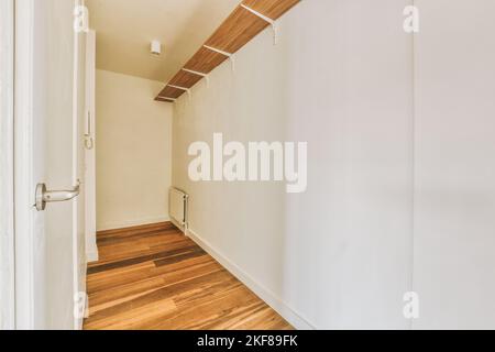 Interior of modern flat in minimal style with narrow empty corridor illuminated by lamps Stock Photo