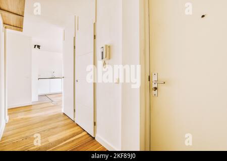 Interior of modern flat in minimal style with narrow empty corridor illuminated by lamps Stock Photo
